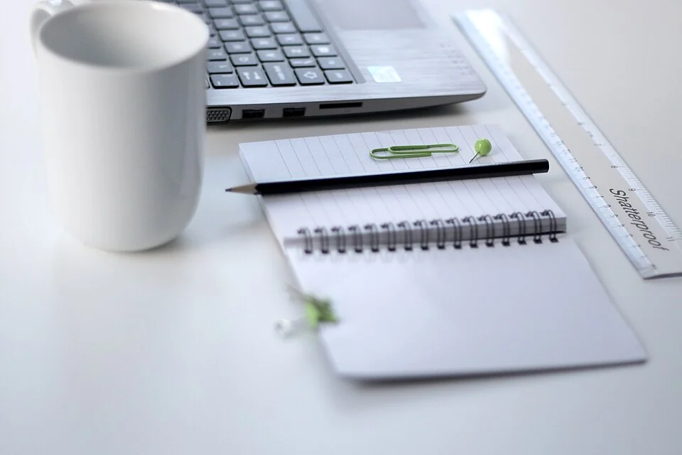 Een laptop, notitieboek en pen klaar om plannen te maken